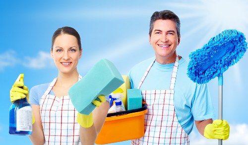 Cleaner wearing PPE while handling cleaning materials safely
